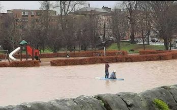 Paddleboarders take to water in flooded park after downpours