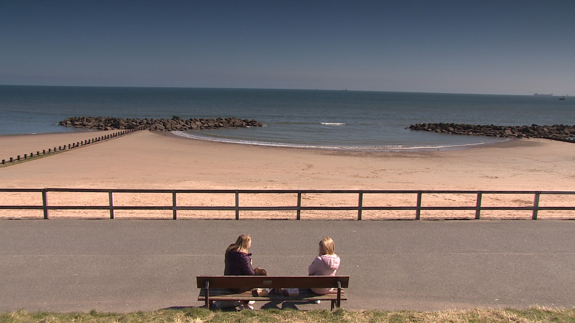 Two people meet together on a bench in Aberdeen.