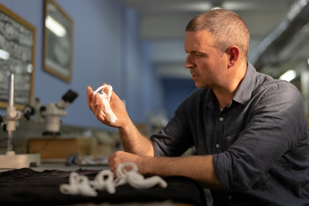 Professor Jonah Choiniere holding a 3D printed model of the Shuvuuia lagena (Jonah Choiniere/Wits University/PA)