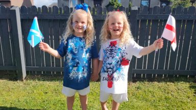 Twins cheer against each other in England v Scotland match