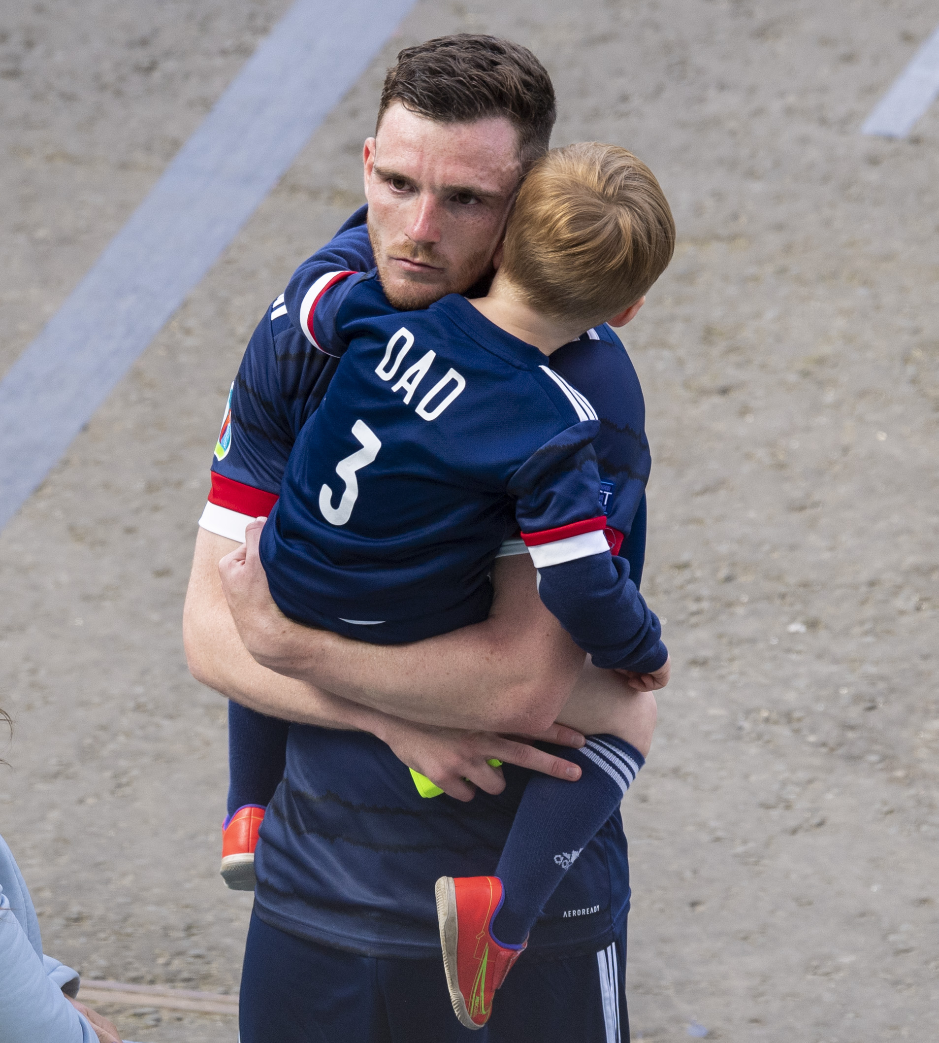 Andy Robertson is consoled by his young son at full-time.