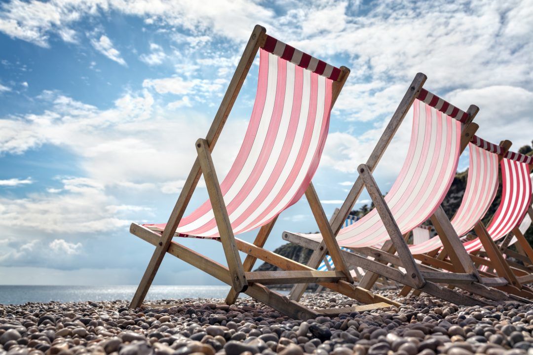 Deck chairs on the beach at the seaside on summer vacation