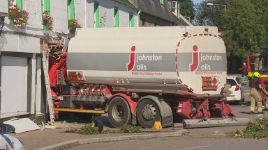 Street locked down after tanker hits car and crashes into building