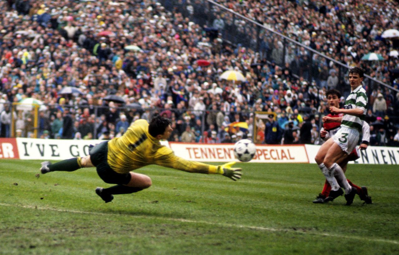 Celtic goalkeeper Pat Bonner pushes a shot from Clydebank's John Davies round the post.