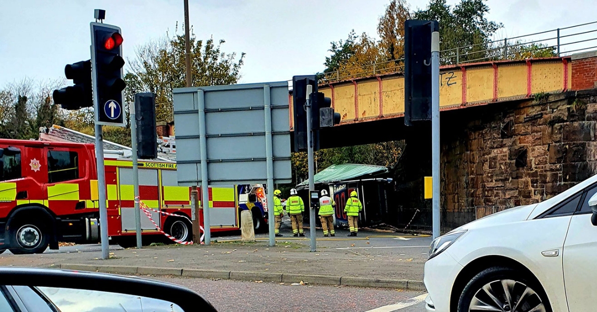 Lorry overturns on major road after striking railway bridge