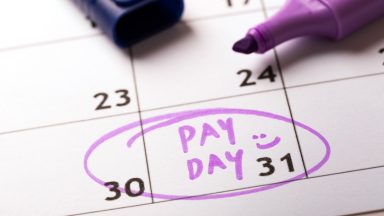 Stock image of calendar with 'pay day' marked.