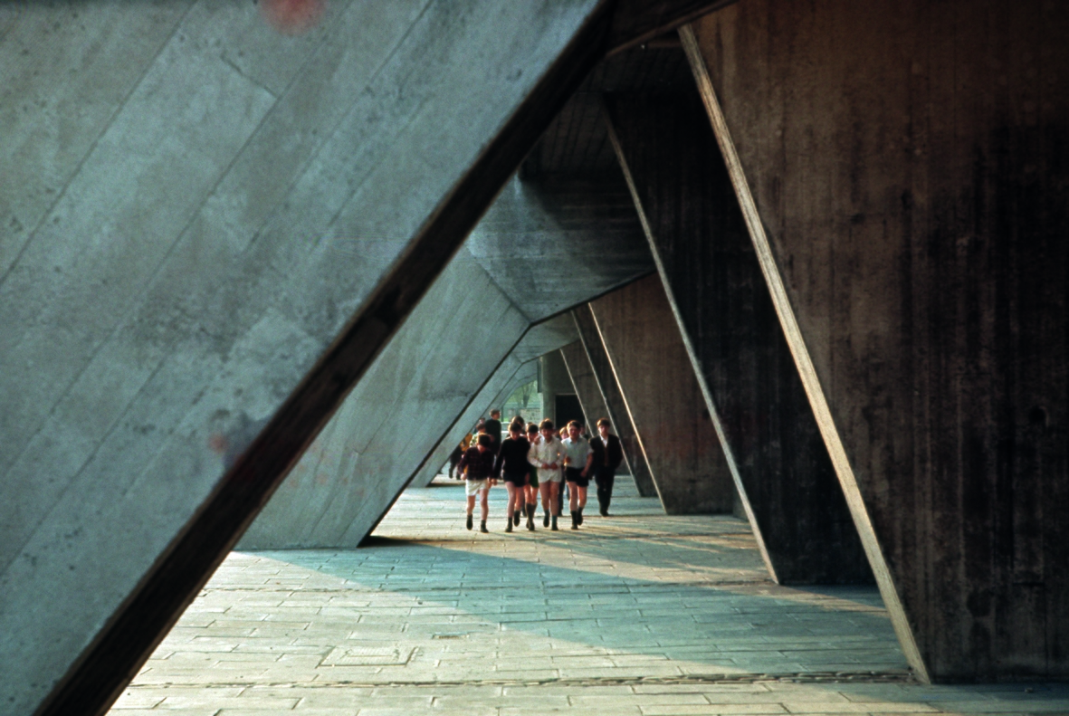 Boys walking under Queen Elizabeth Square building.