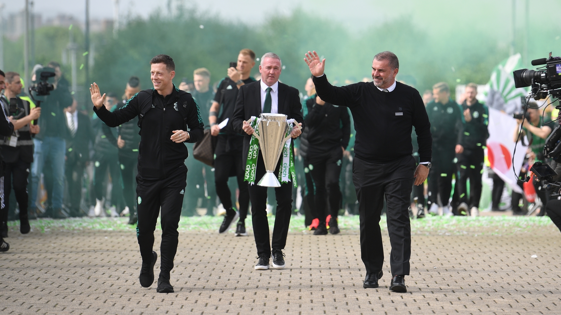 Paul Lambert carries the cinch Premiership Trophy alongside Ange Postecoglou and Callum McGregor.