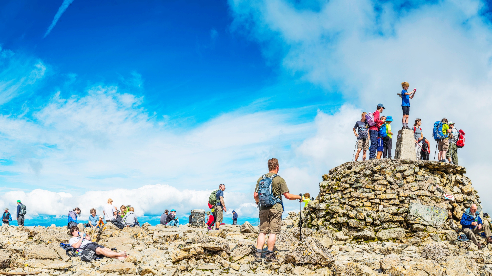 Crowds of hikers enjoying the summer sunshine on the summit of Ben Nevis, Britain's highest mountain.