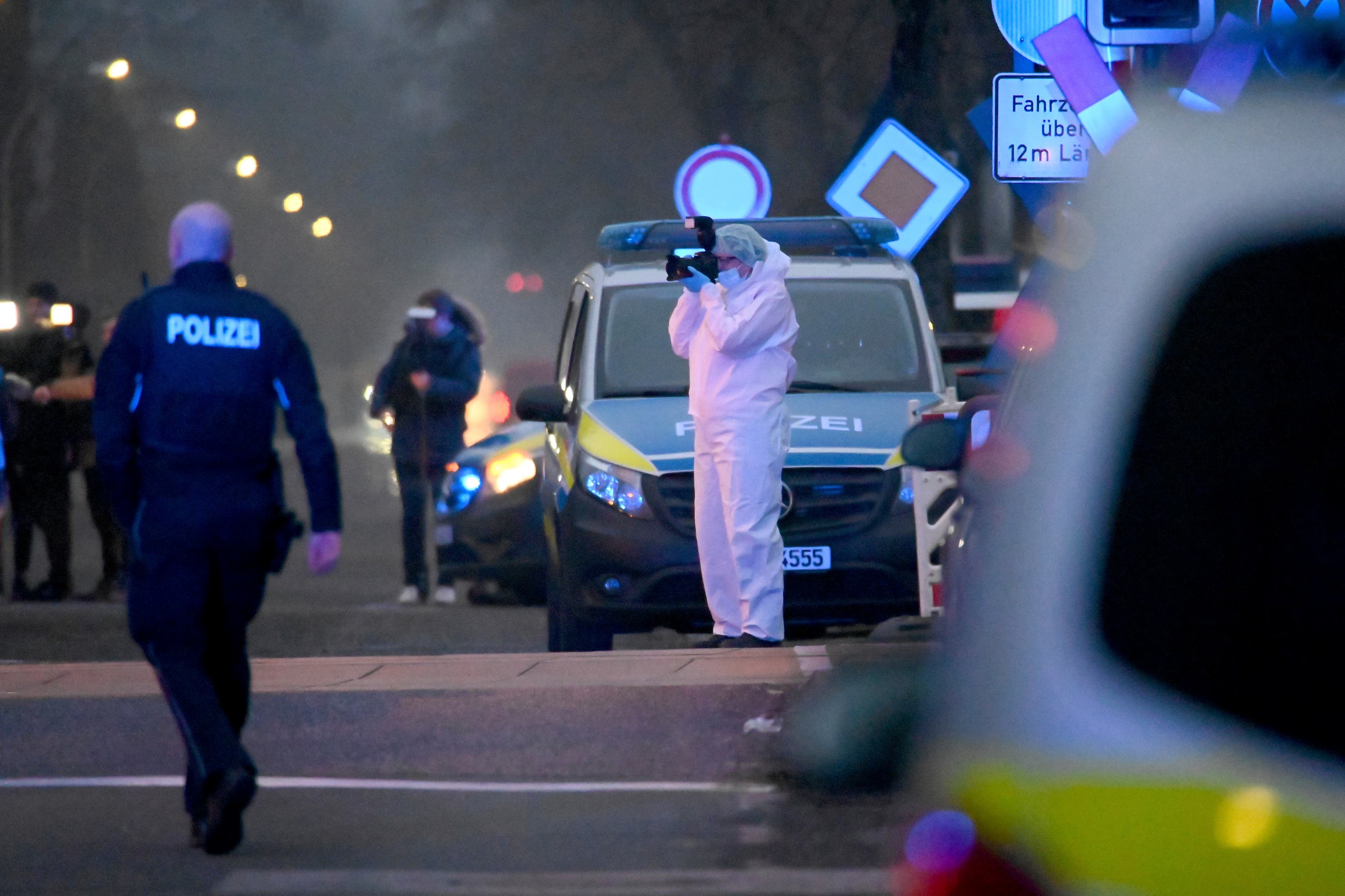 Police and forensic teams work at a level crossing near Brokstedt station in Germany.