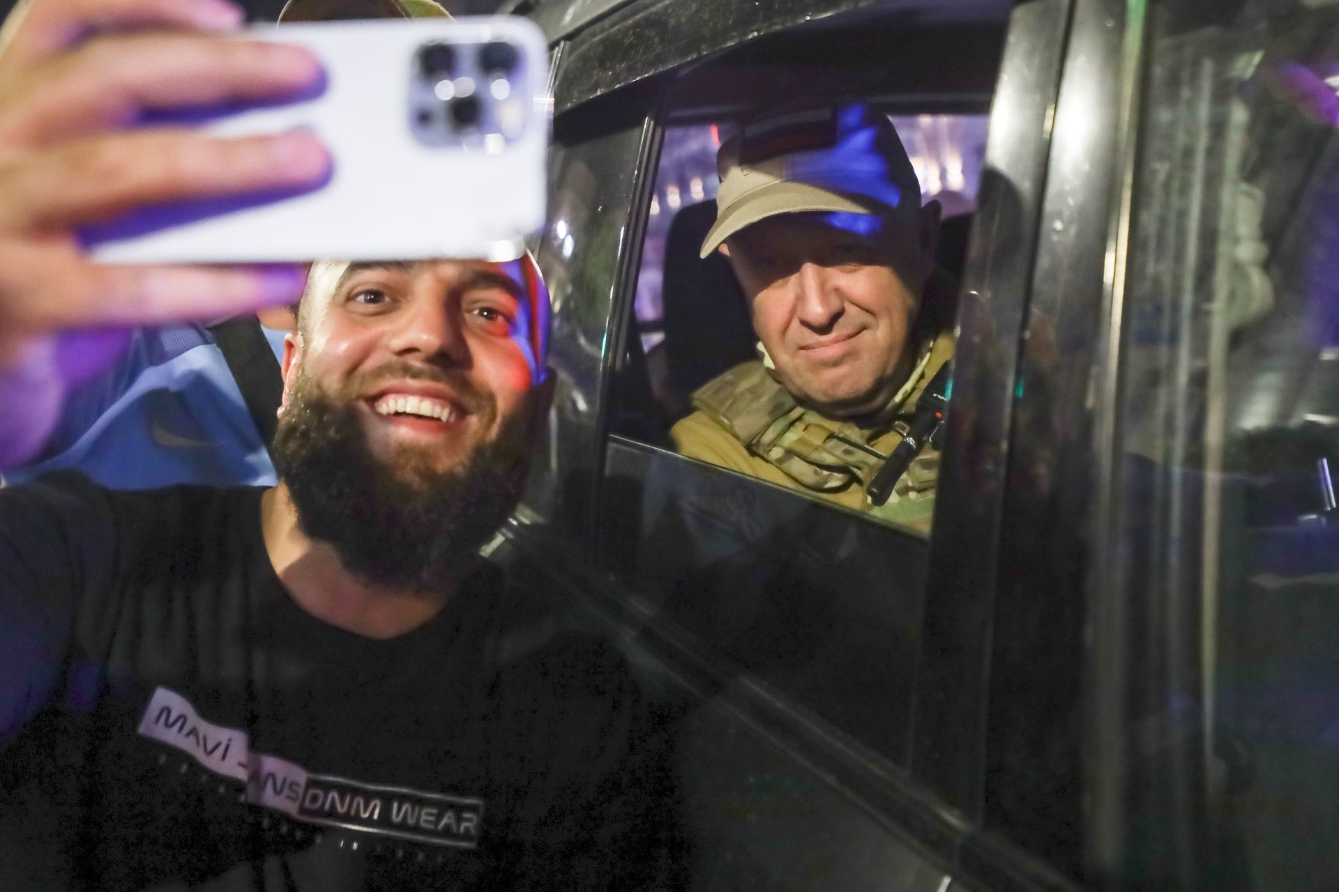 Yevgeny Prigozhin sits inside a military vehicle posing for a selfie with a civilian in Rostov-on-Don, Russia.