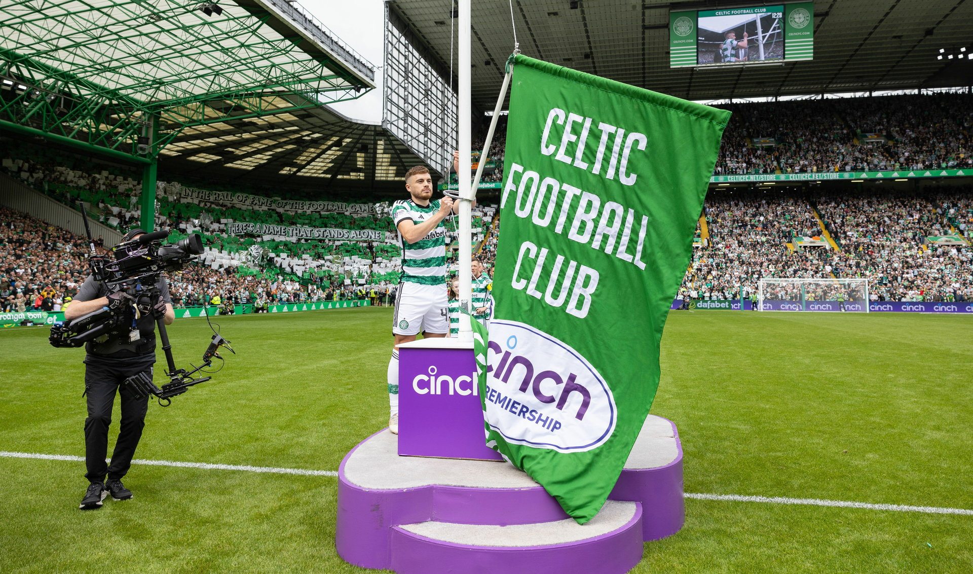 Celtic's James Forrest unfurls the league flag ahead of Premiership opener. (Photo by Craig Foy / SNS Group)