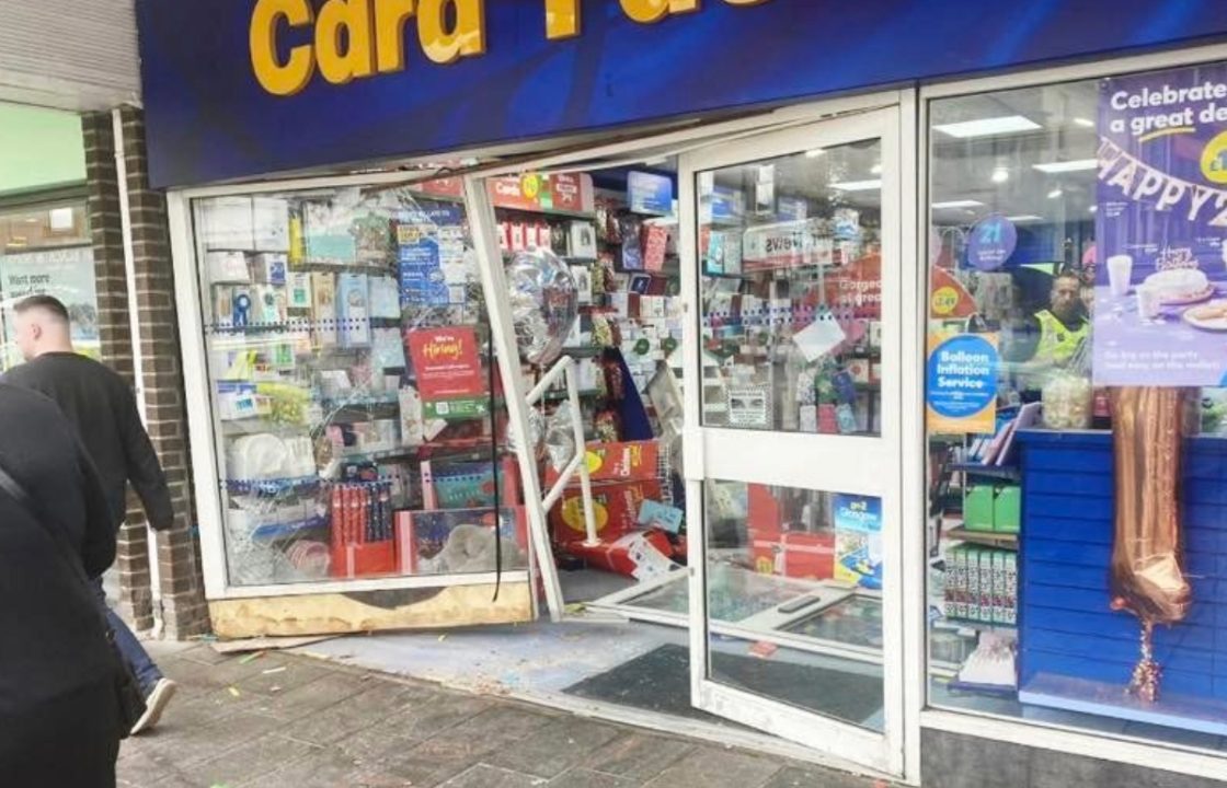 Man reported after car rolls down hill and smashes into card shop