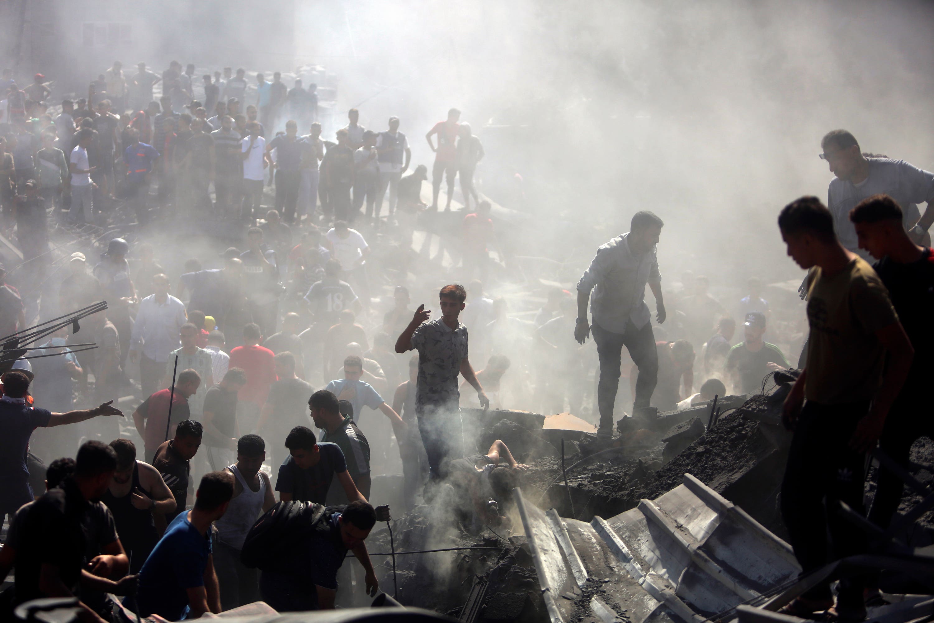 Palestinians inspect the rubble of destroyed buildings following Israeli airstrikes on the town of Khan Younis, southern Gaza Strip.