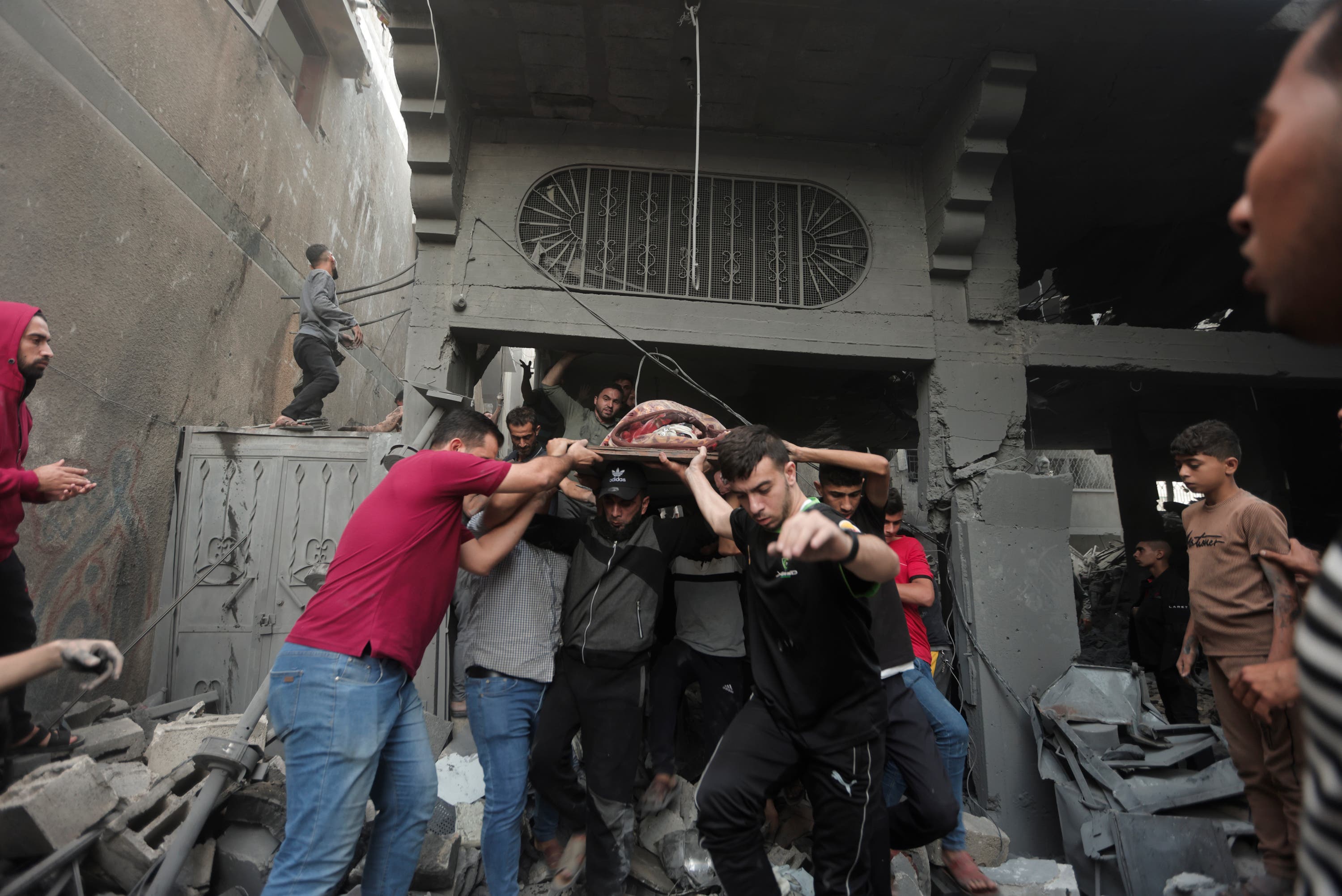 Palestinians evacuate an injured woman found under the rubble of a destroyed house following an Israeli airstrike in Khan Younis refugee camp, southern Gaza Strip, on Saturday.