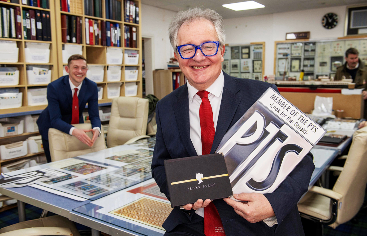 Gordon holding book with his son Austin in the background.