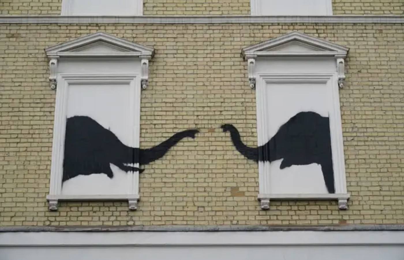 A new artwork depicting two elephants poking their heads out of blocked out windows appeared on the side of a building in Chelsea