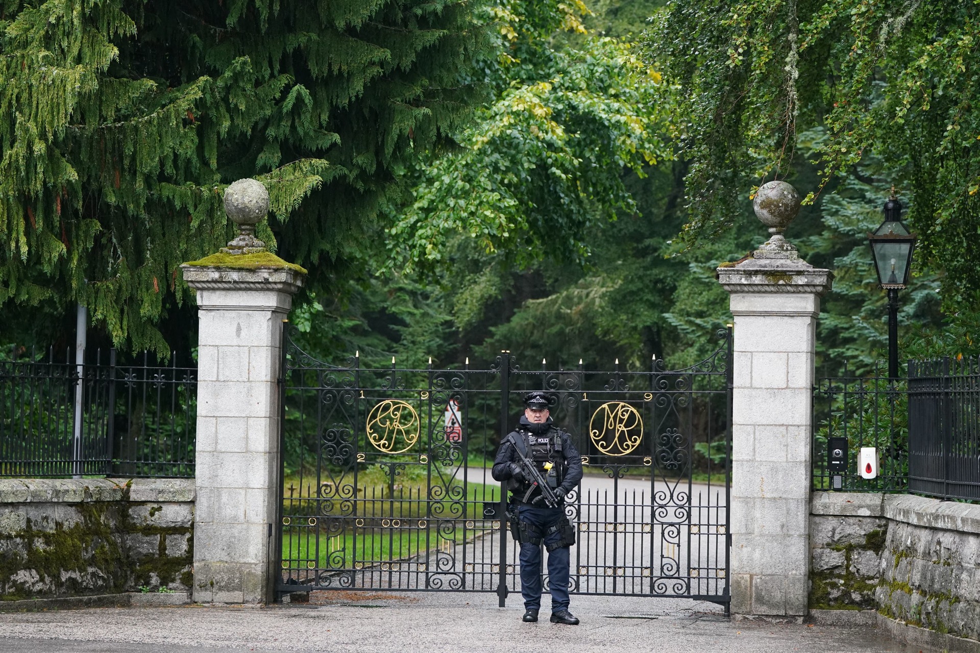 An armed police officer at the gates to Balmoral while the Queen was under medical supervision (Andrew Milligan/PA).