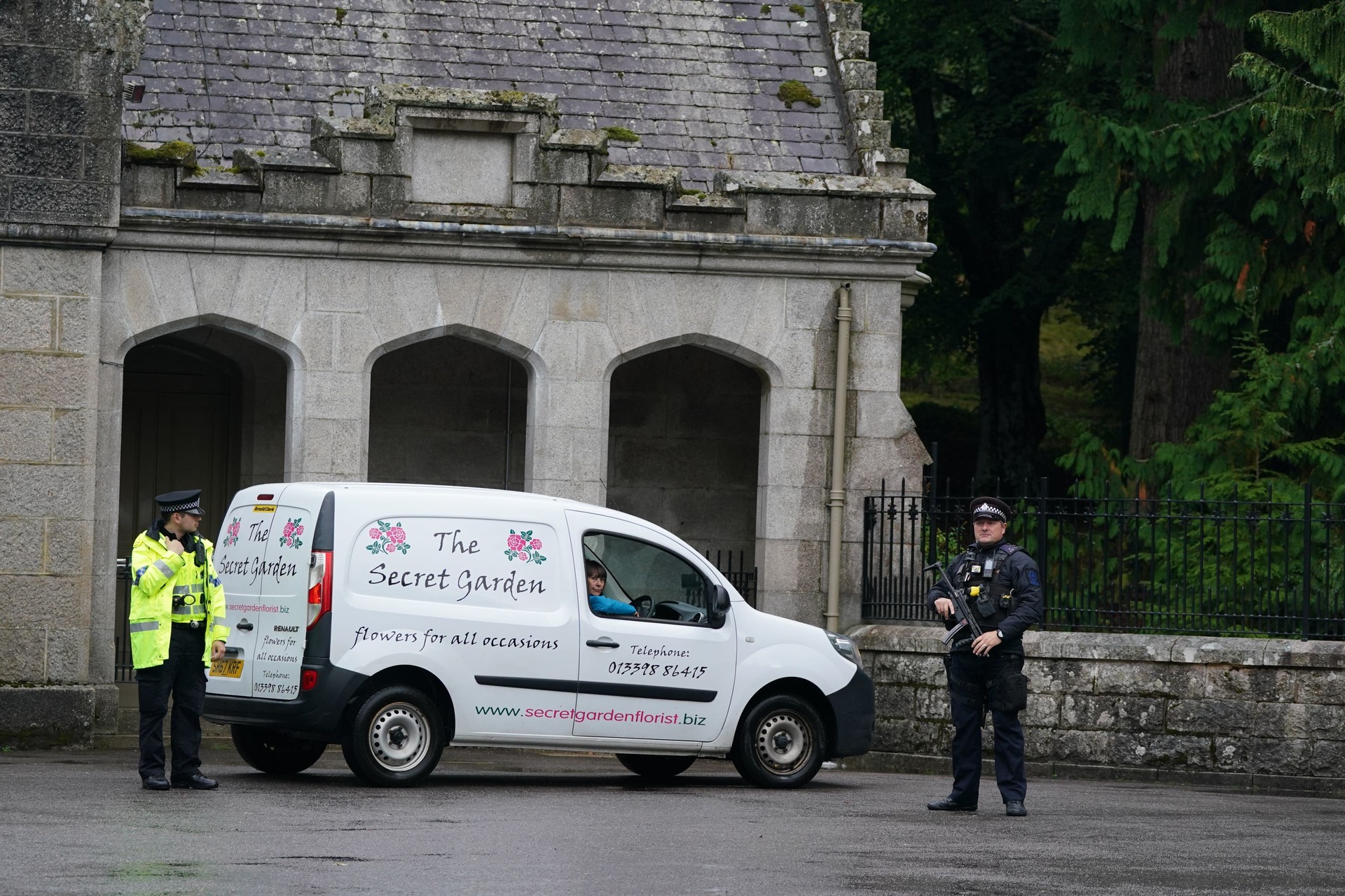 A florist van arrives at the gates, which are guarded by an armed police officer after the Palace announces the Queen is under medical supervision (Andrew Milligan/PA). 