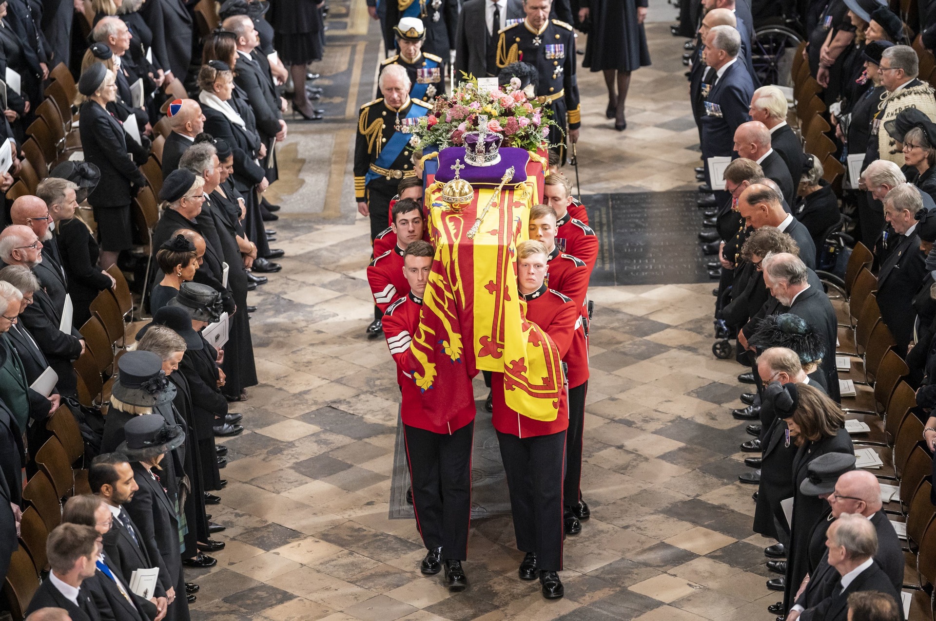 Elizabeth II’s coffin, draped in the Royal Standard with the Imperial State Crown and the Sovereign’s orb and sceptre, is carried out of Westminster Abbey after her state funeral (Danny Lawson/PA). 