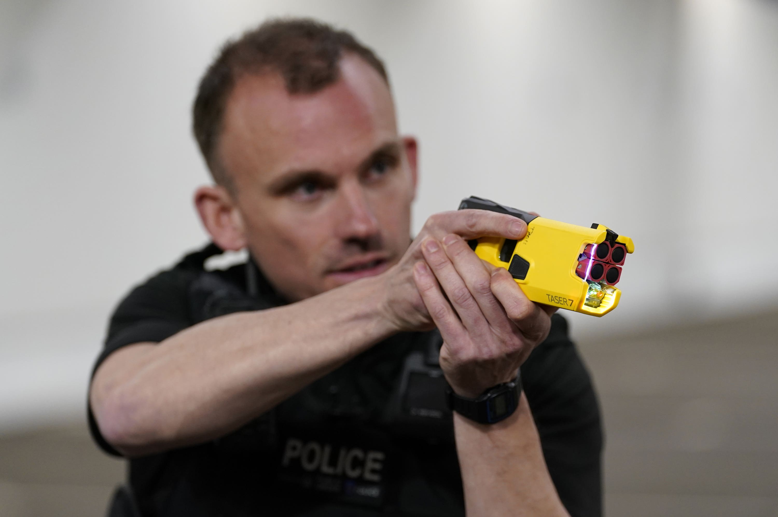 A police officer demonstrates how to use a taser.