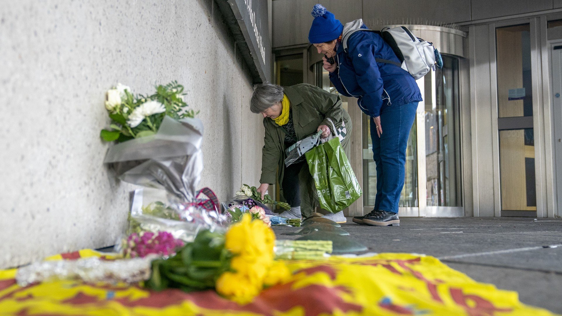 Members of the public place flowers outside the Scottish Parliament in Edinburgh after Alex Salmond died