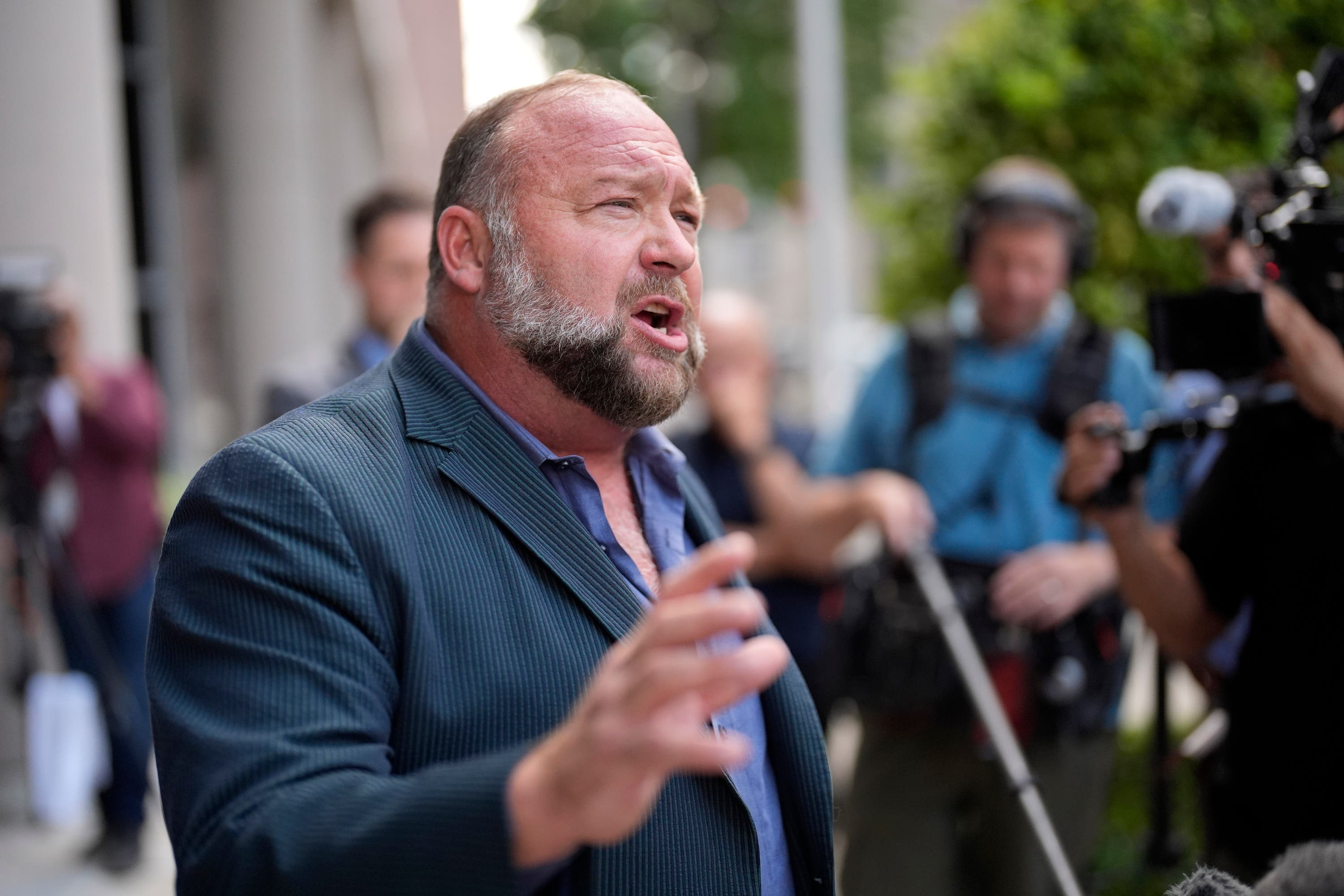 Right-wing conspiracy theorist Alex Jones speaks to the media after arriving at the federal courthouse for a hearing in front of a bankruptcy judge (AP/David J Phillip) 