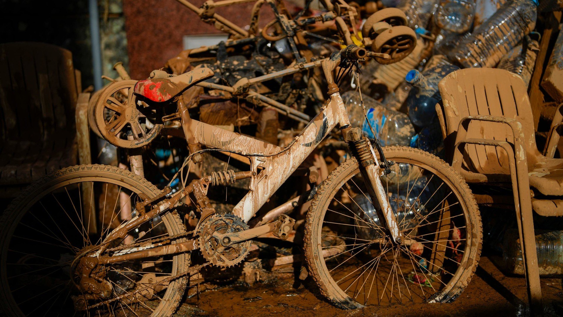 Mud covers a bicycle and various belongings in Valencia, Spain