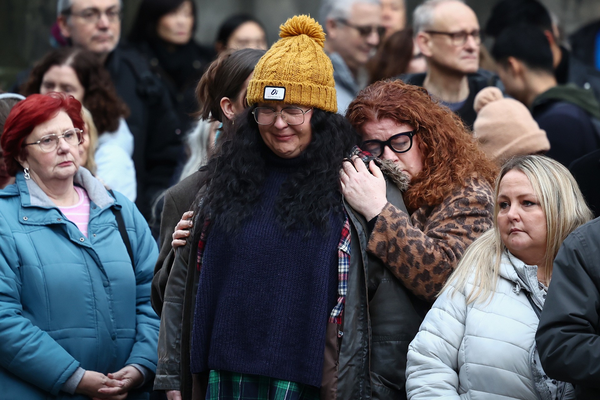 Ashley Storrie, daughter of Janey Godley (in hat) reacts as the hearse carrying her mother makes it's way down The Royal Mile 