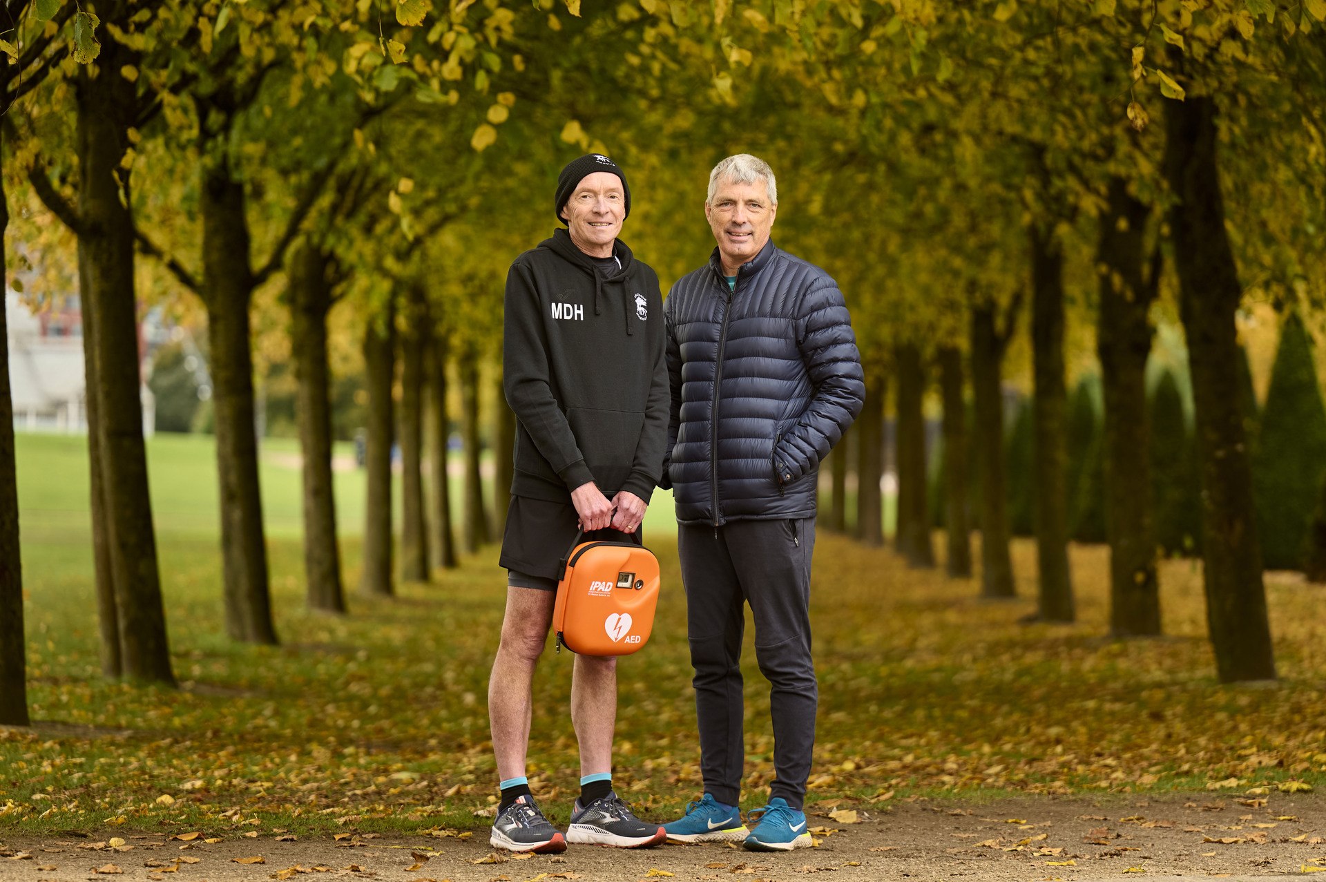 (L-R) Malcolm Hughes and Stephen Lappin in Glasgow Green with the defib which saved their lives.