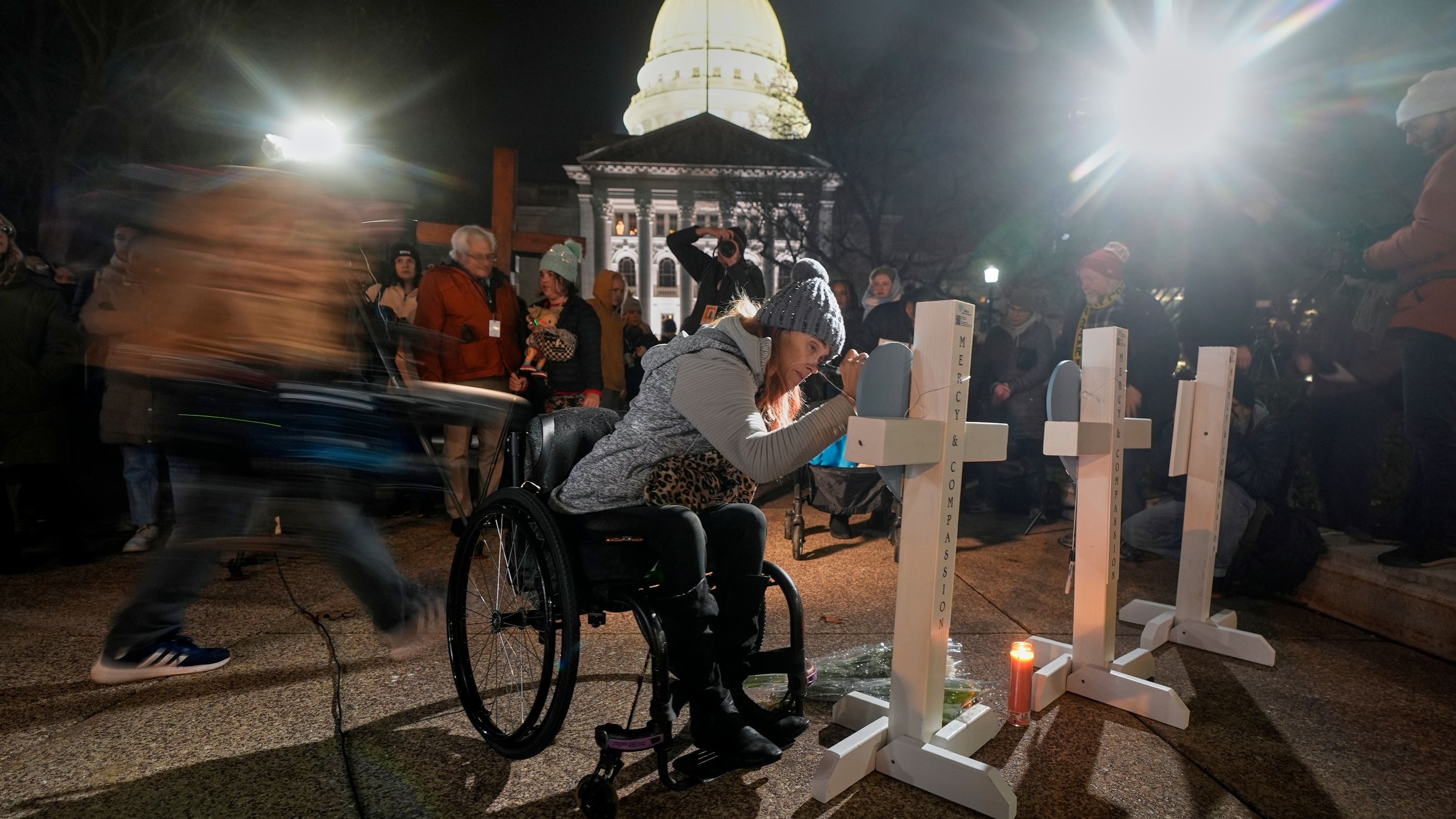 A supporter signs a cross during a candlelight vigil outside the Wisconsin Capitol in Madison 