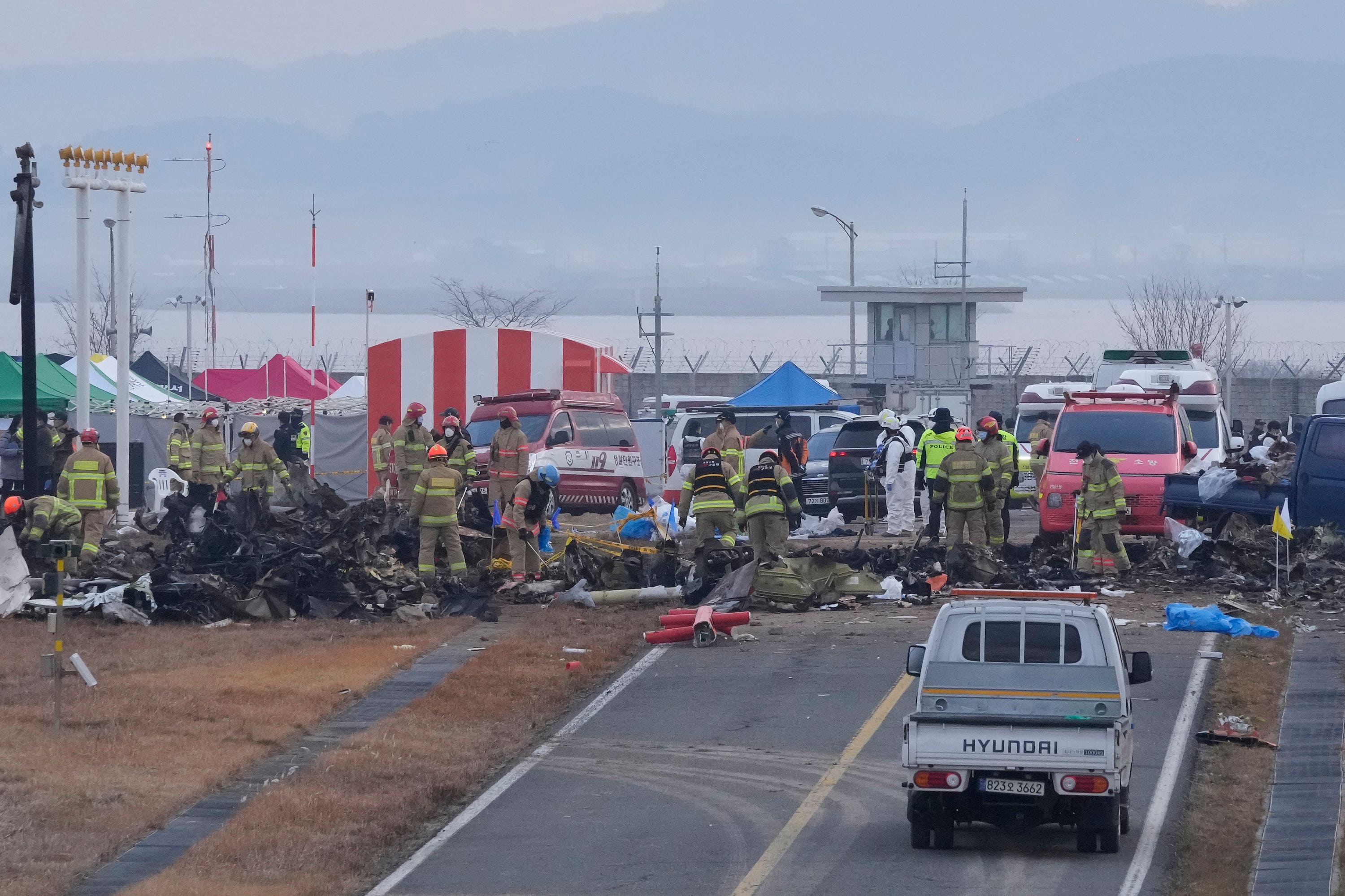 Rescue team members work at the site of a plane fire at Muan International Airport in Muan, South Korea (AP/Ahn Young-joon). 