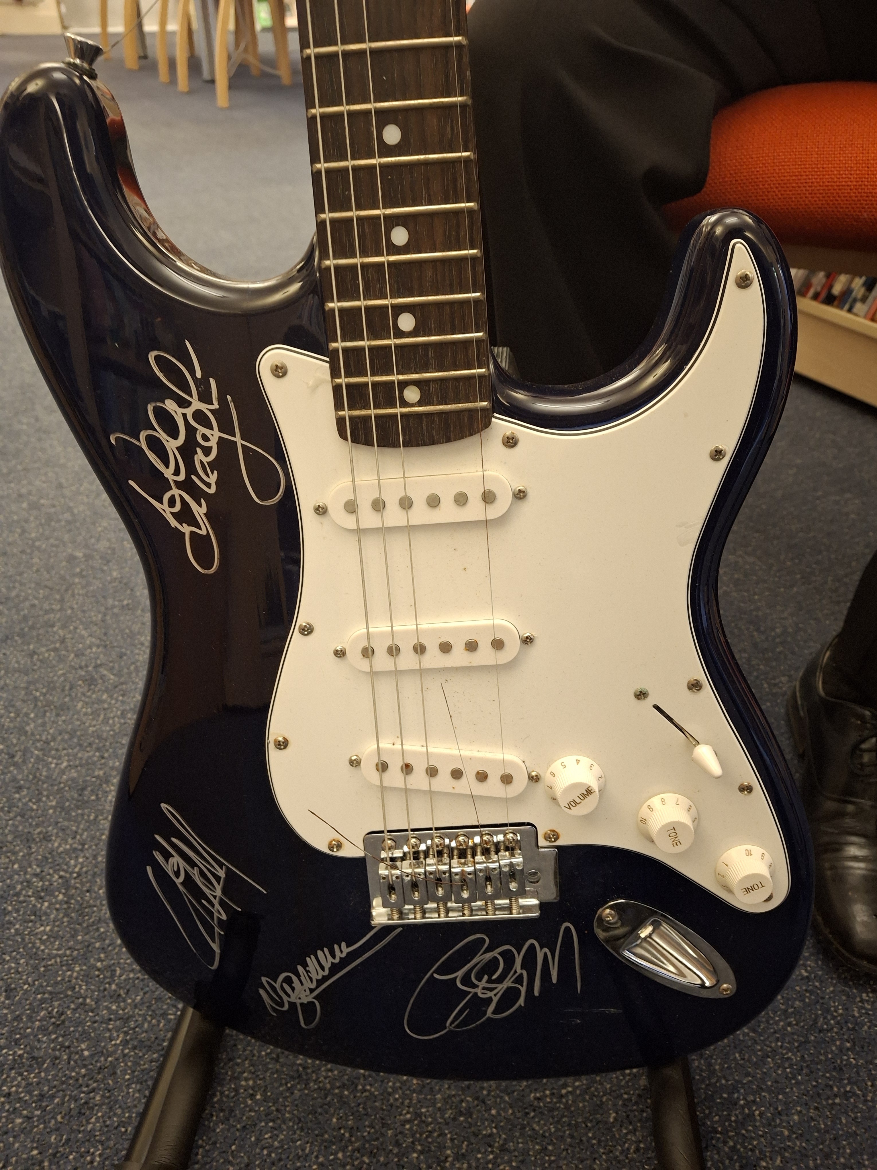 The guitar is signed by the members of Oasis. 