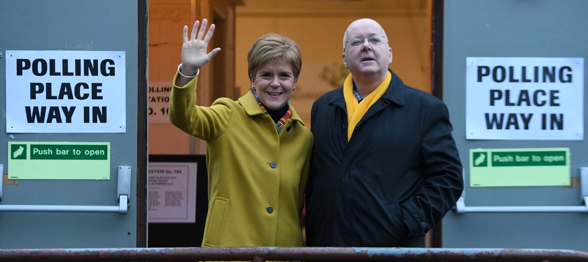 Scotland's First Minister and leader of the Scottish National Party (SNP), Nicola Sturgeon, stands with her husband husband Peter Murrell outside a polling station in Glasgow, on December 12, 2019.