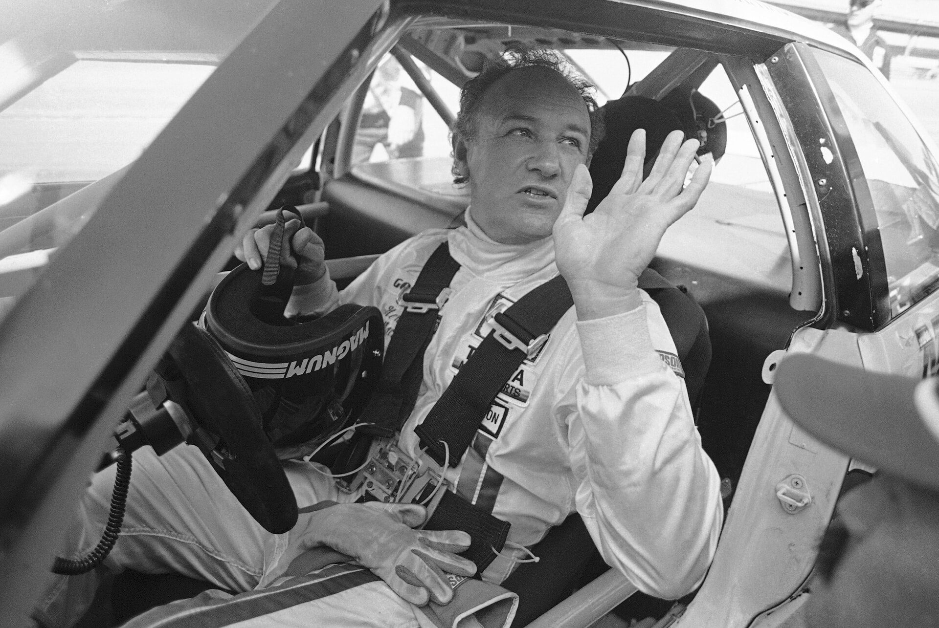 Gene Hackman waves as he starts out for a practice run in his Toyota Celica in 1983