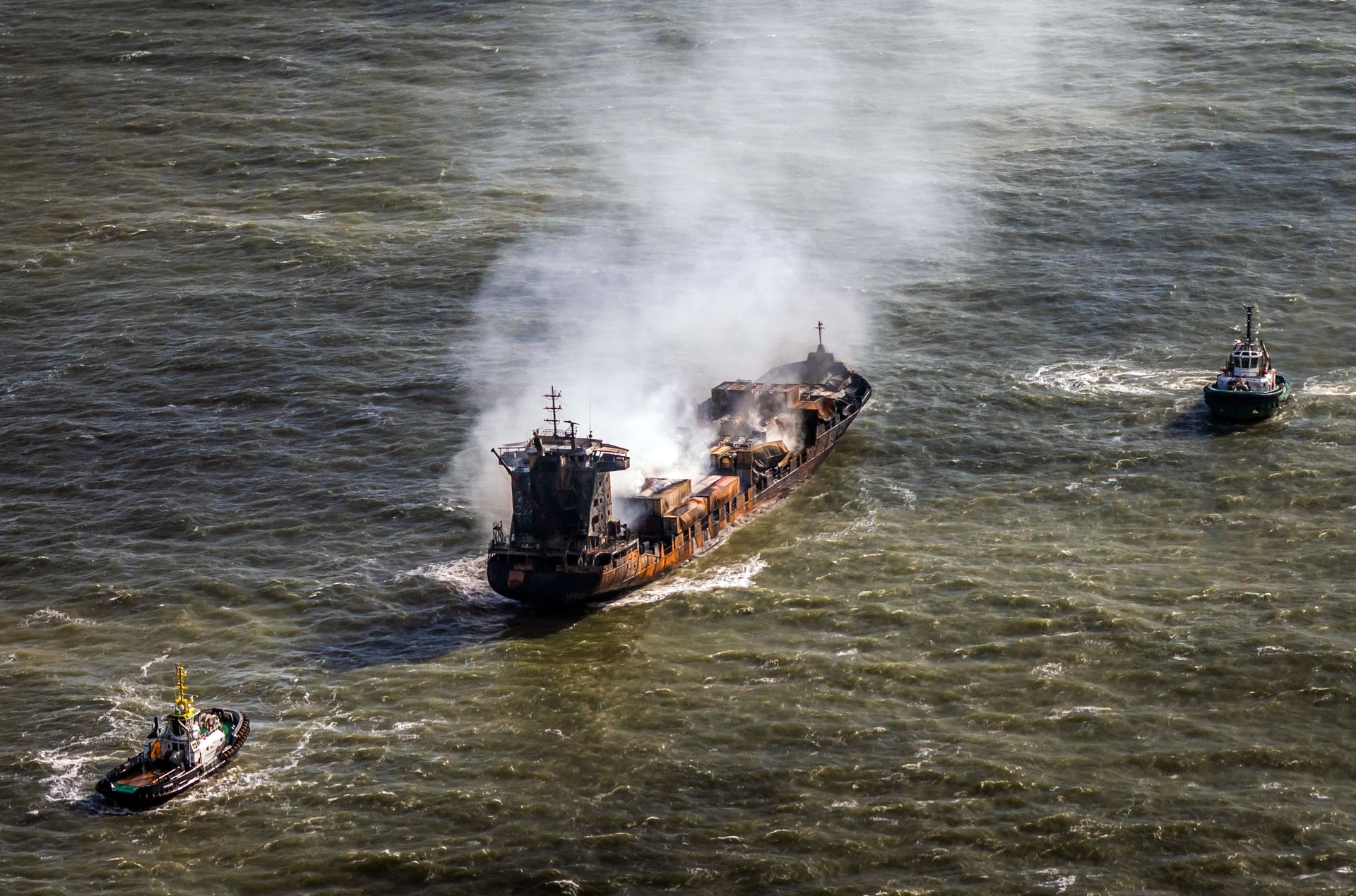 Tug boats shadow the Solong container ship as it drifts in the Humber Estuary following a collision with the Stena Immaculate oil tanker.