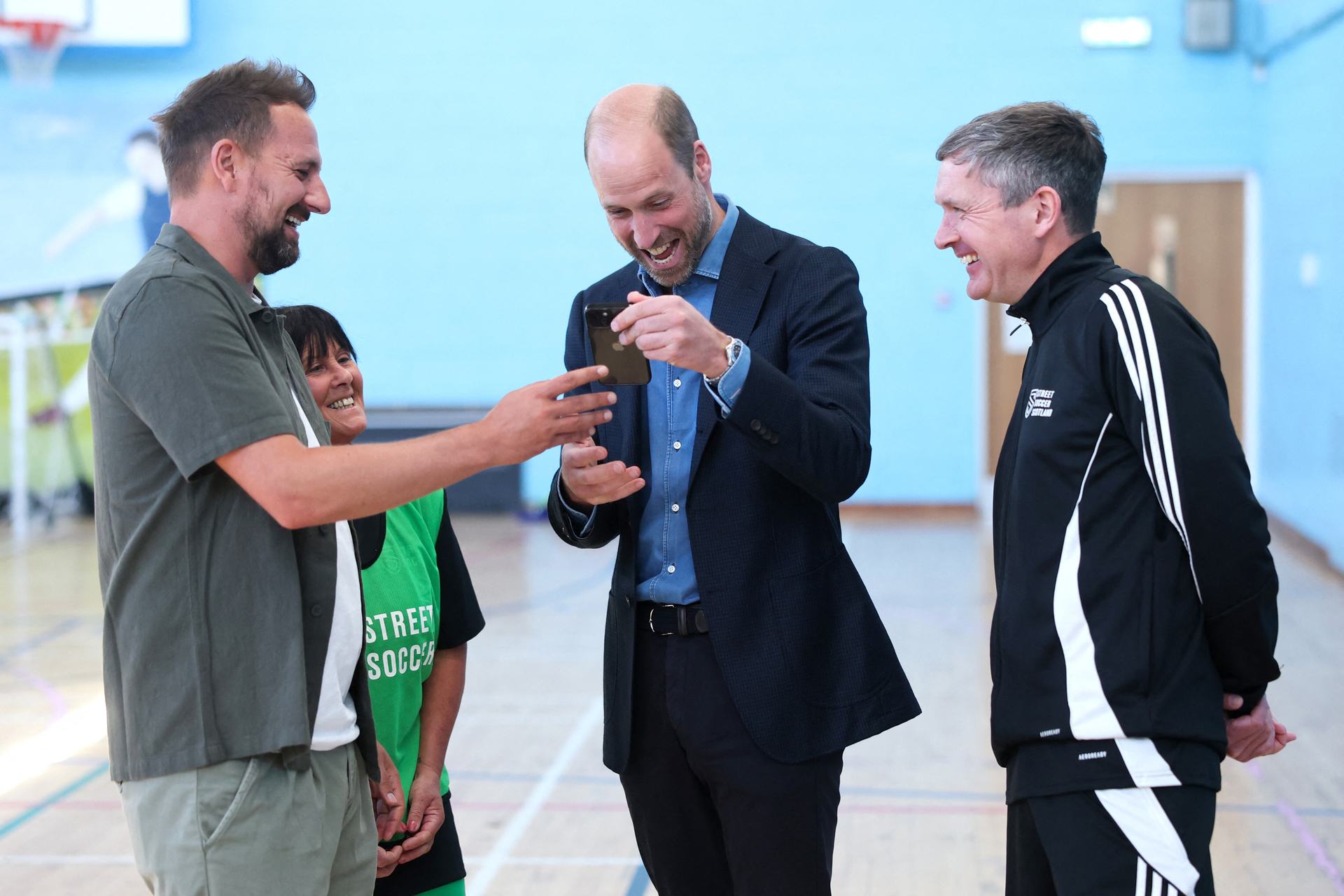 Prince William shares a joke with Street Soccer Scotland founder and CEO David Duke (L), a football coach and player during a visit to Leith Community Centre.