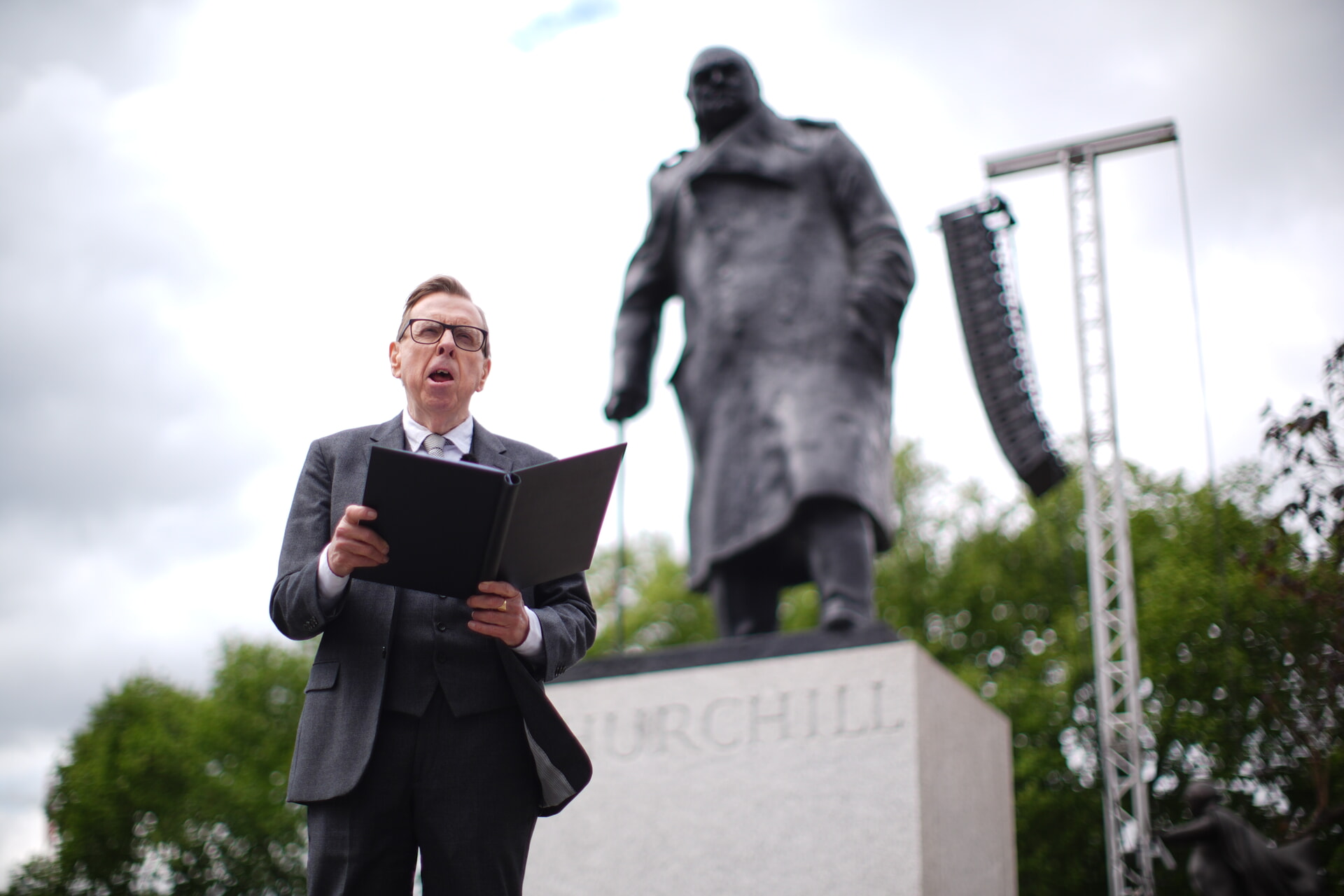 Actor Timothy Spall performs his reading of Sir Winston Churchill's 1945 victory speech in front of a statue of the war time leader.