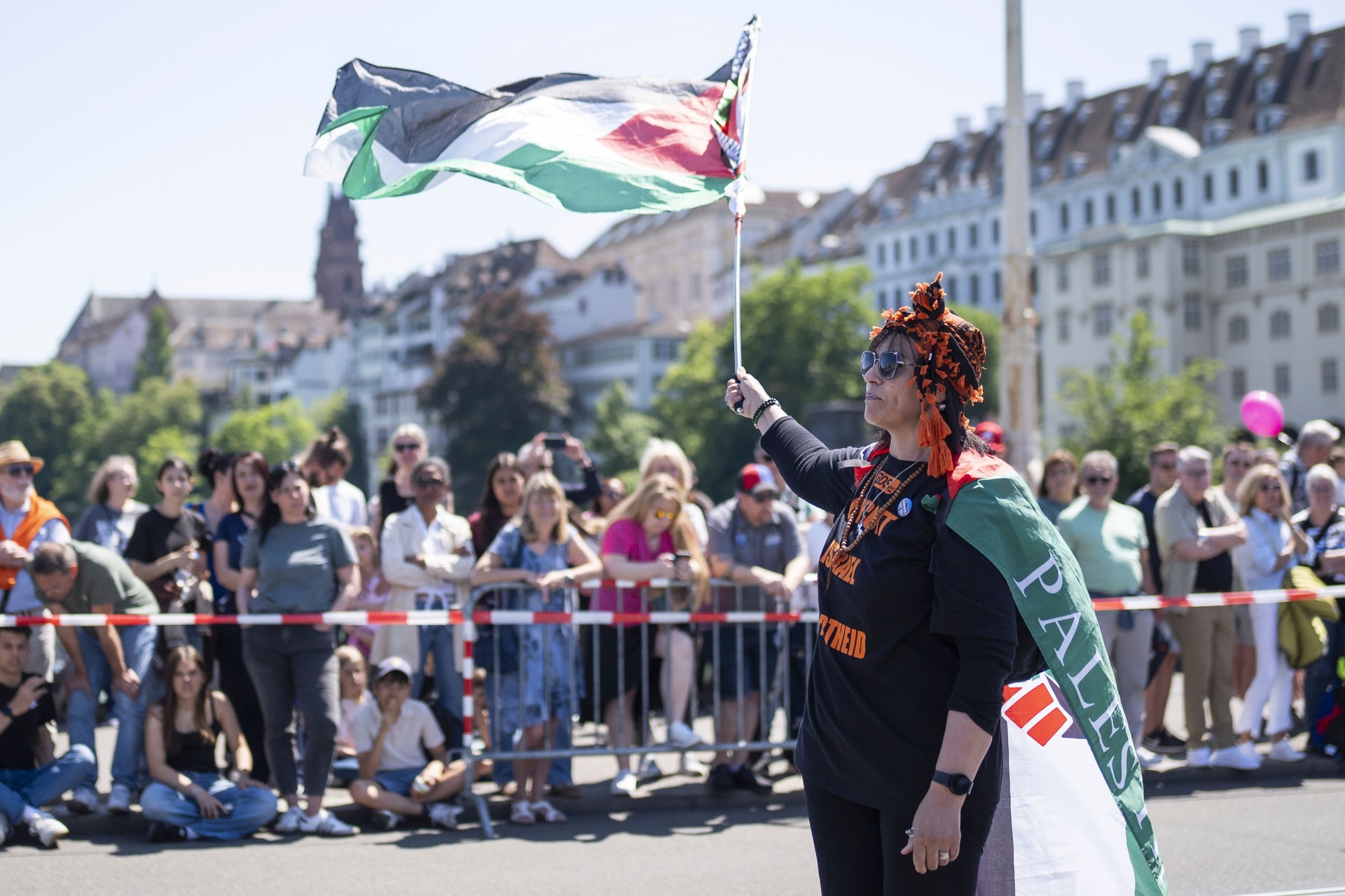 A protester raises a Palestinian flag, during the opening ceremony of the 69th Eurovision Song Contest, in Basel, Switzerland, on Sunday (Til Buergy/Keystone via AP).