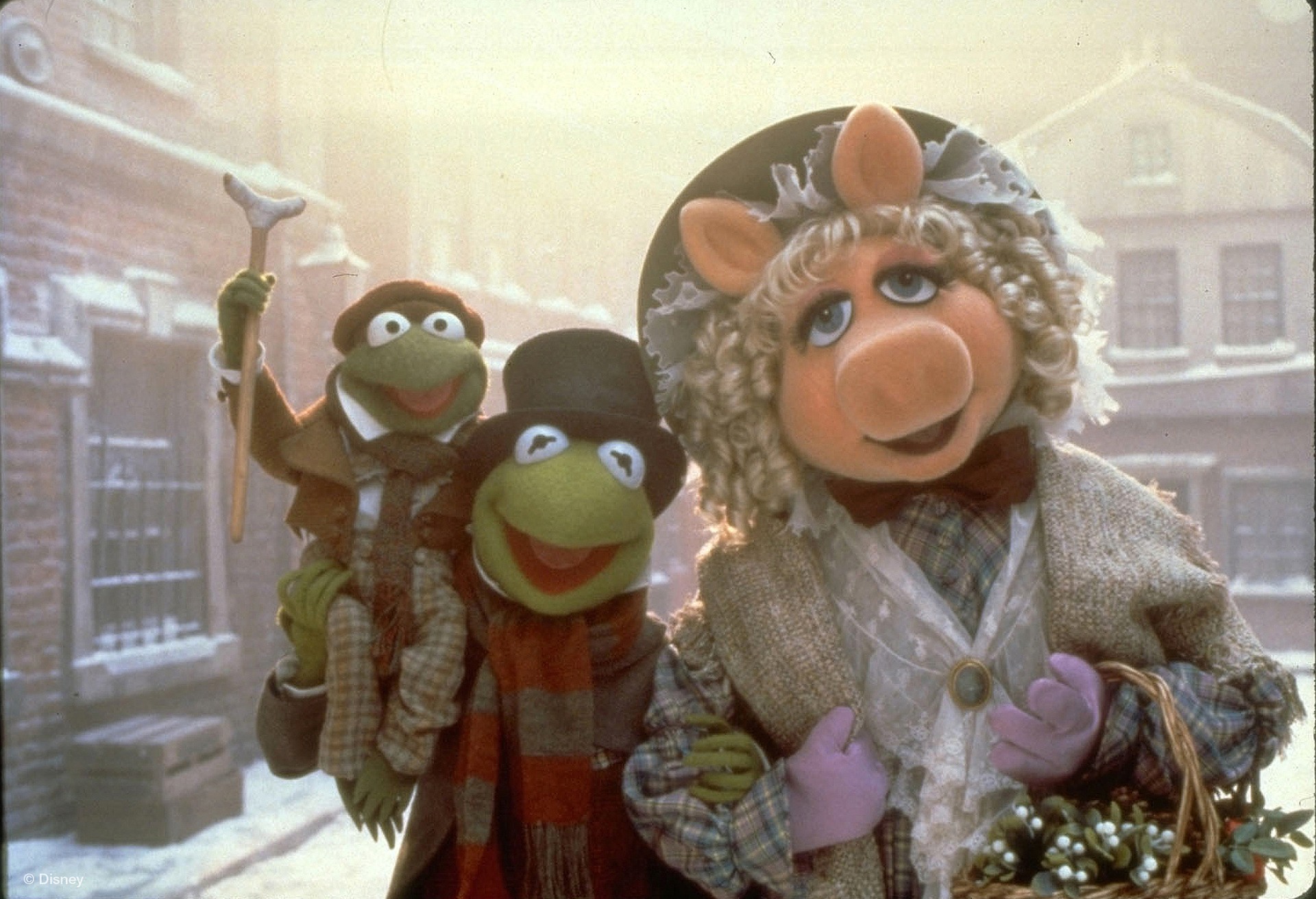 Kermit the Frog as Bob Cratchit, Miss Piggy as Emily Cratchit and Robin the Frog as Tiny Tim.