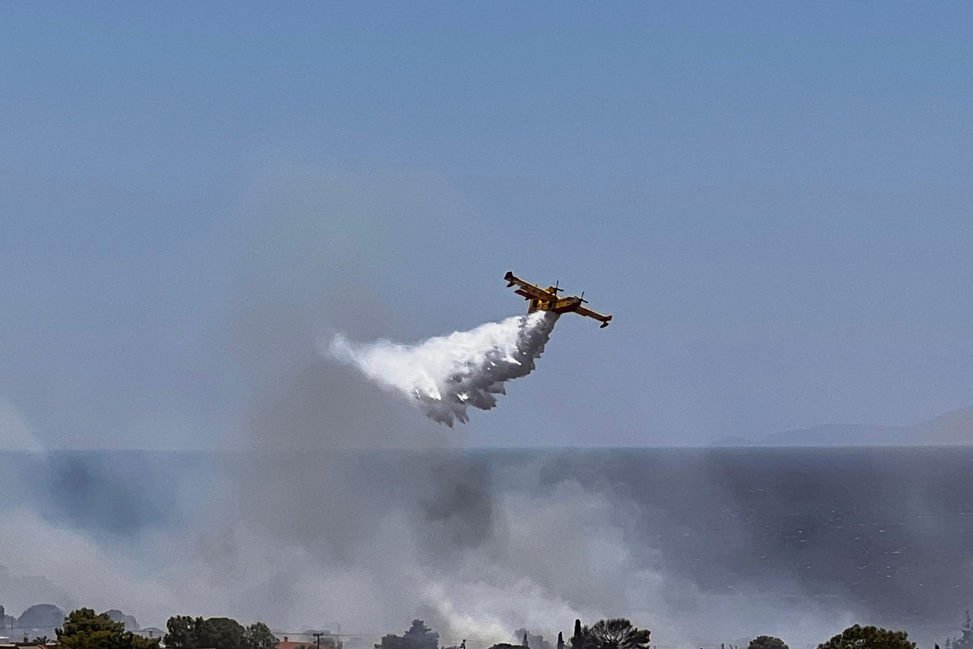 A firefighting plane drops water while battling the blaze.