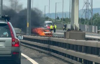 Section of M8 closed after vehicle catches fire as drivers warned of delays
