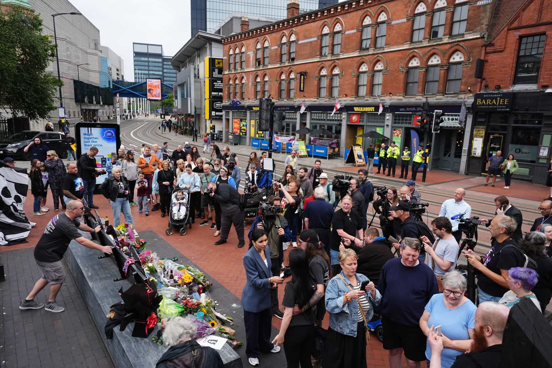 Floral tributes are left on the Black Sabbath Bridge bench on Broad Street in Birmingham (Jacob King/PA).