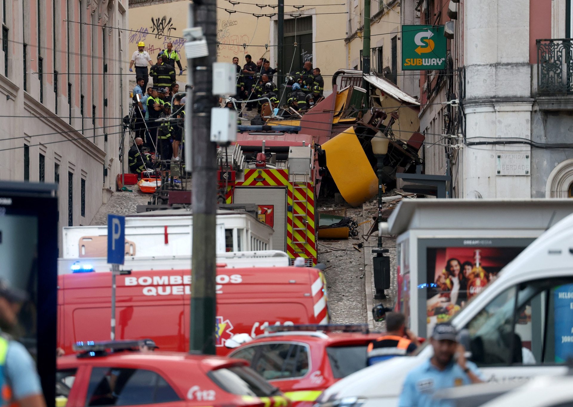 Police and firefighters work on the site of the Gloria funicular railway accident in Lisbon.