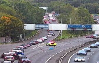 Tractor driver dies after trailer load of timber crashes onto motorway in Glasgow