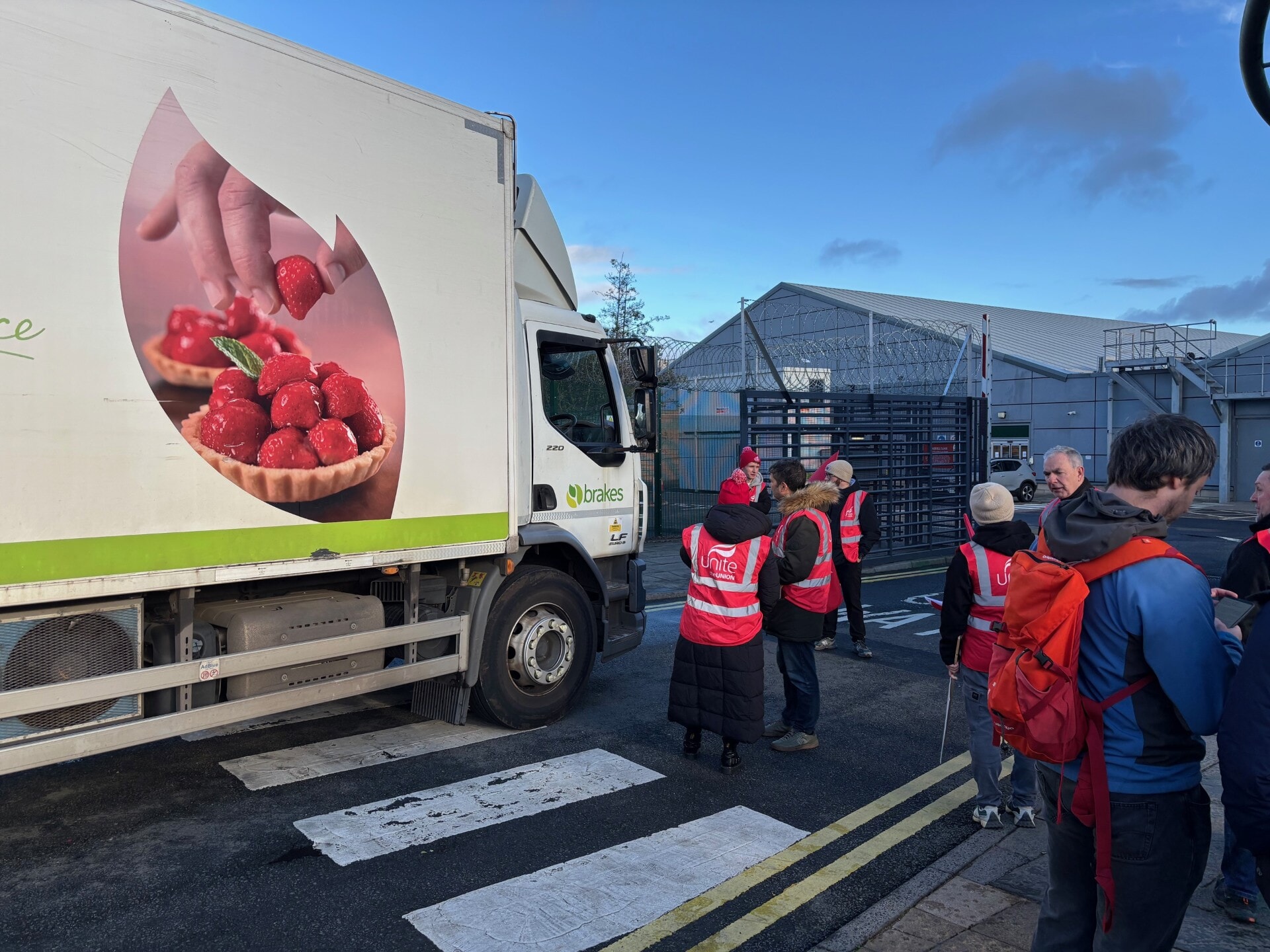 Many of the striking workers waved red Unite banners