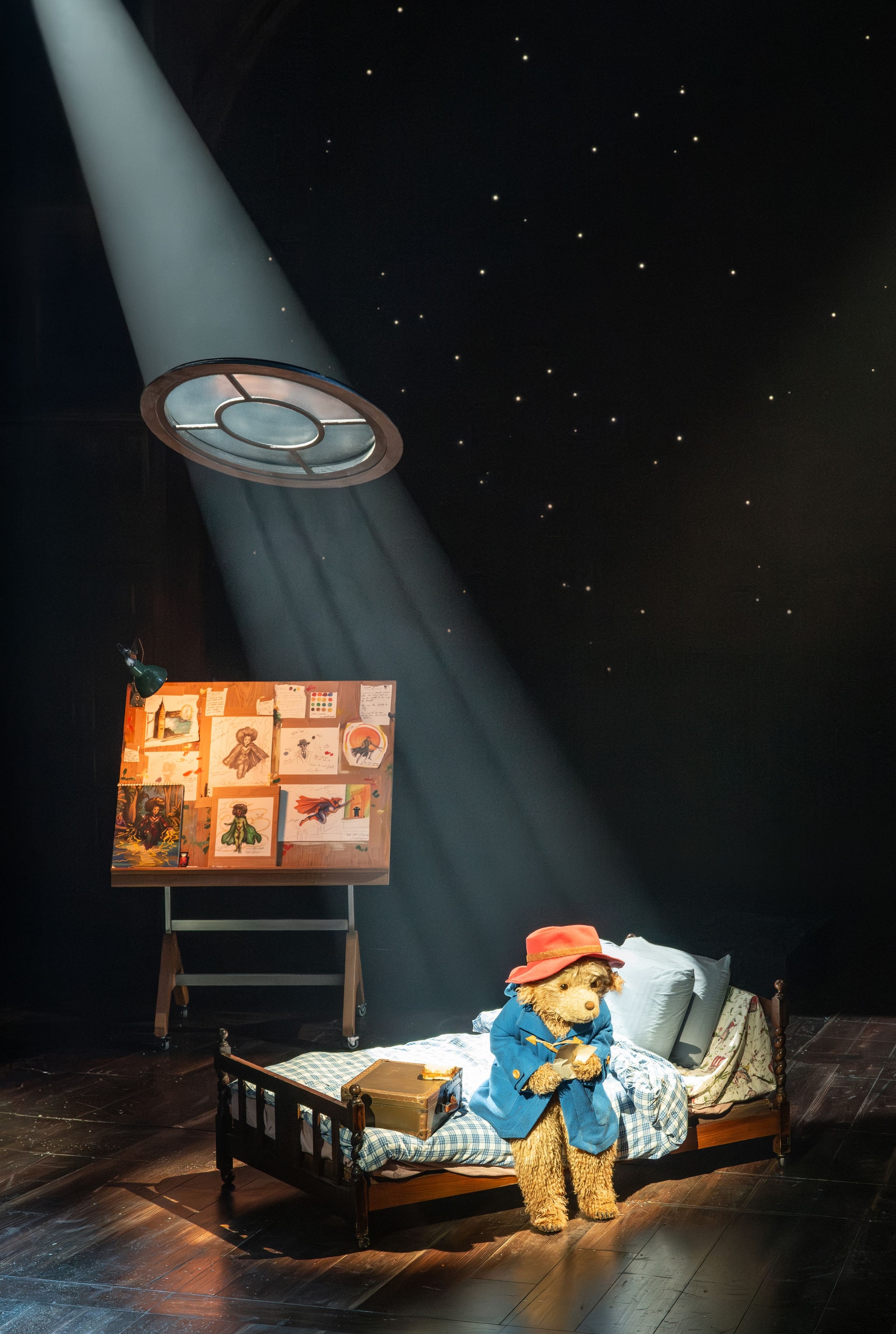 Paddington Bear sits on a bed during the stage show (Johan Persson/PA).