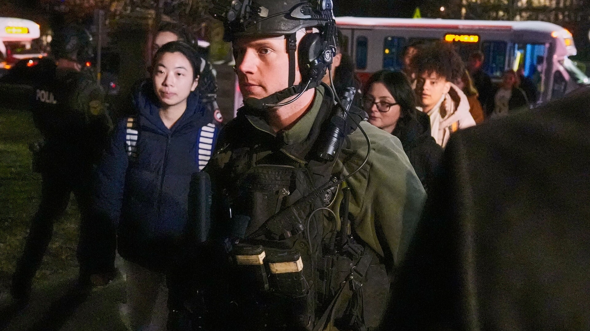 Students are escorted by law enforcement officers to a building at the university after the shooting.