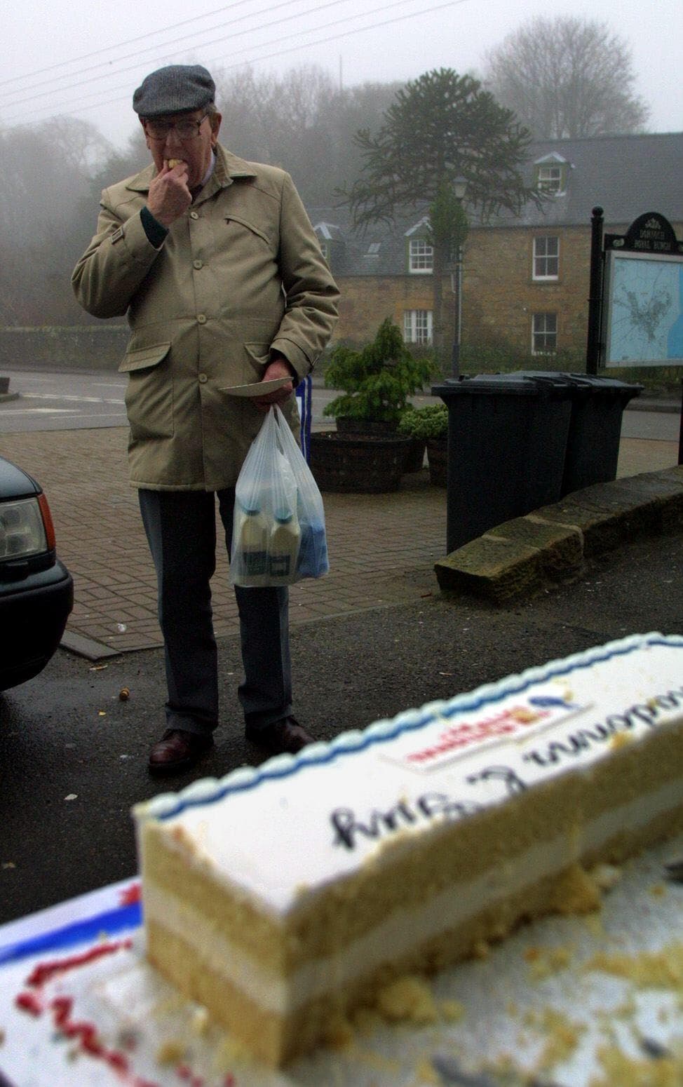 A Dornoch resident eats a piece of wedding cake made by the local tourist board after pop star Madonna and film director Guy Ritchie announced they would marry in nearby Skibo Castle.