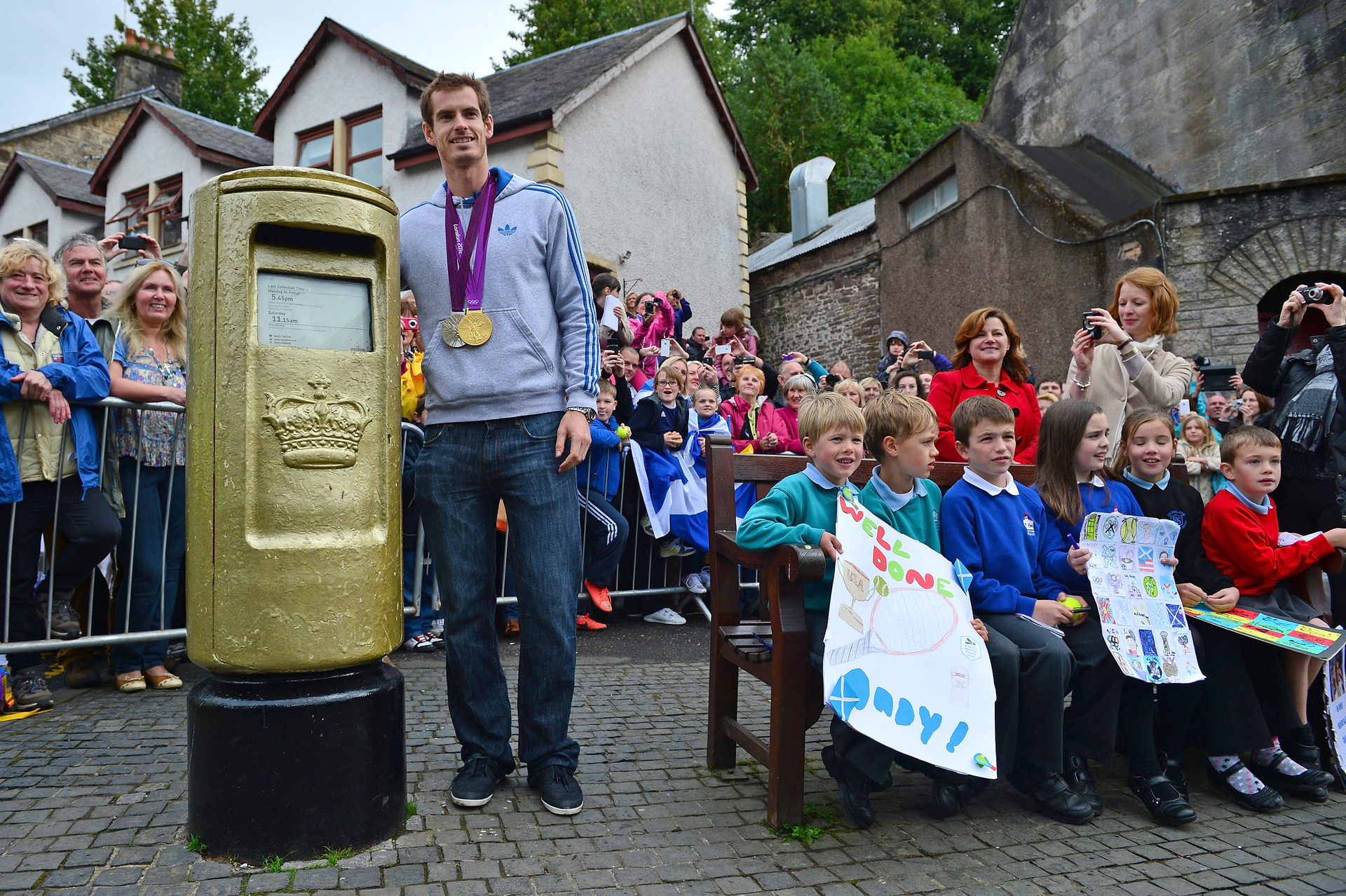 Andy Murray poses next to a post box which was painted gold by the Royal Mail in recognition of his gold medal, after he returned to Dunblane following his win in the US Open and his gold medal in the 2012 Olympic Games in London, on September 16, 2012